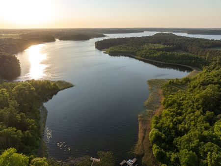 Schaalsee with green trees on both banks, bathed in sunlight.