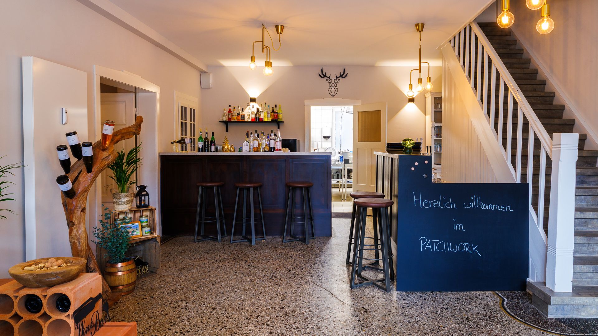 Eingangsbereich Patchwork Landhaus Köthel Blick in eine Diele mit Bar in einem Restaurant.