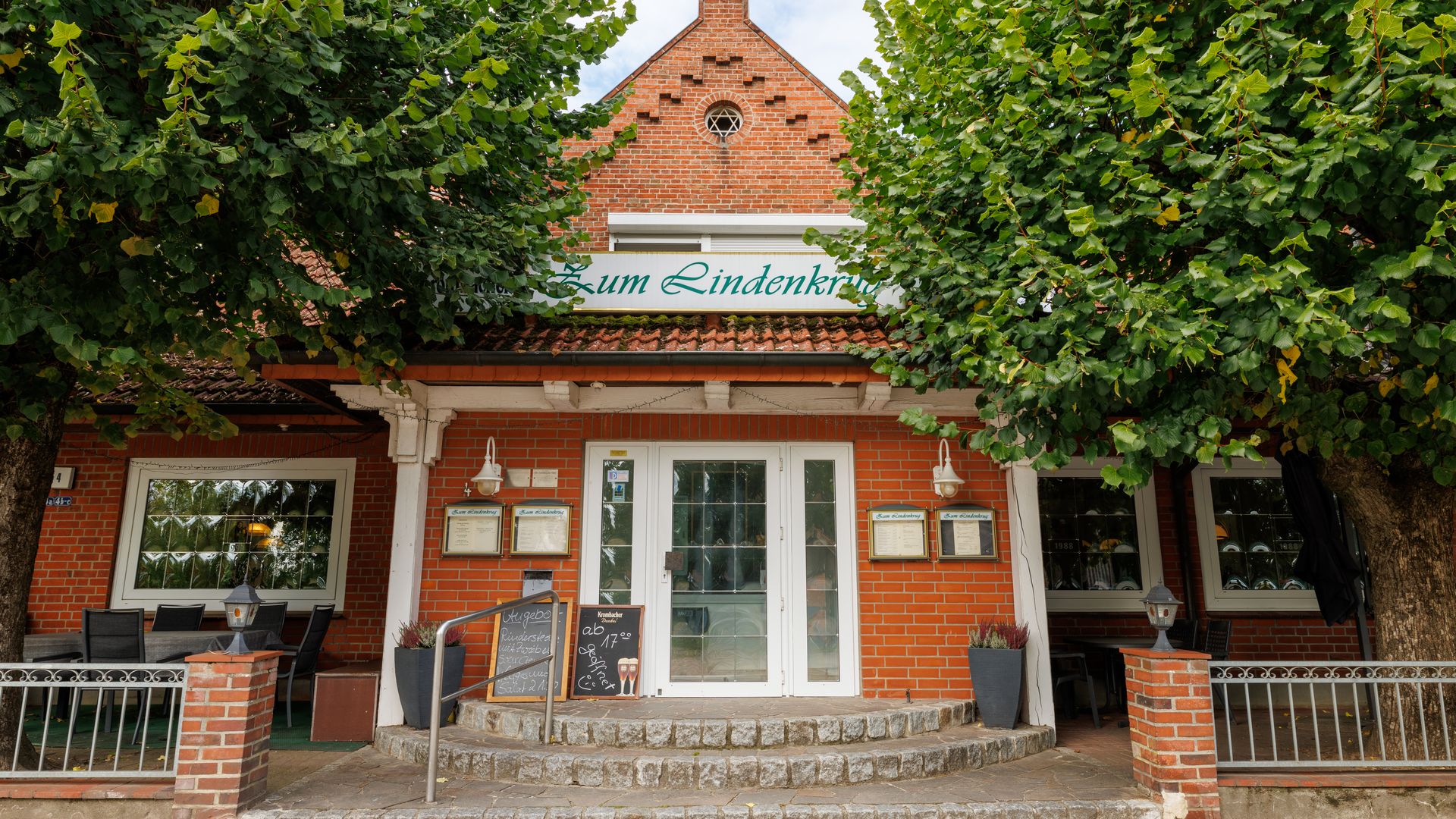 Eingangstür eines Landgasthofes mit Bäumen davor