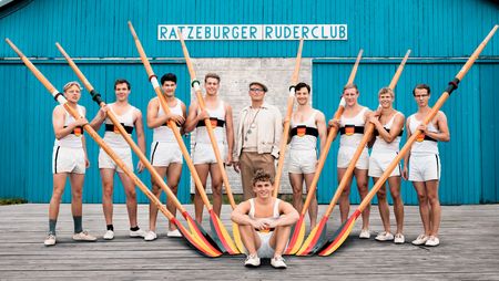 Schauspieler des Kinofilms Adams Acht in Ruderkleidung mit Ruderpaddeln vor dem Gebäude des Ratzeburger Ruderclubs
