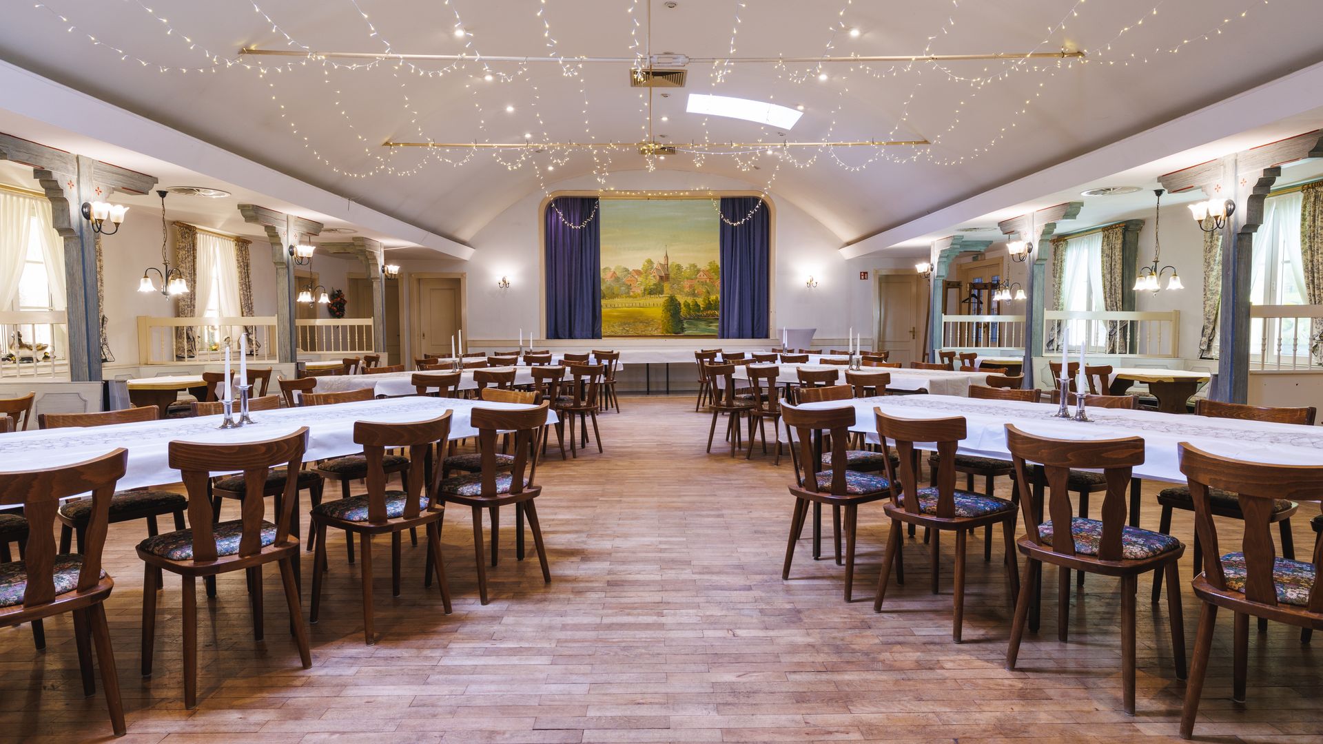 Großer Saal zum Feiern mit Tischen und Stühlen und festlicher Beleuchtung