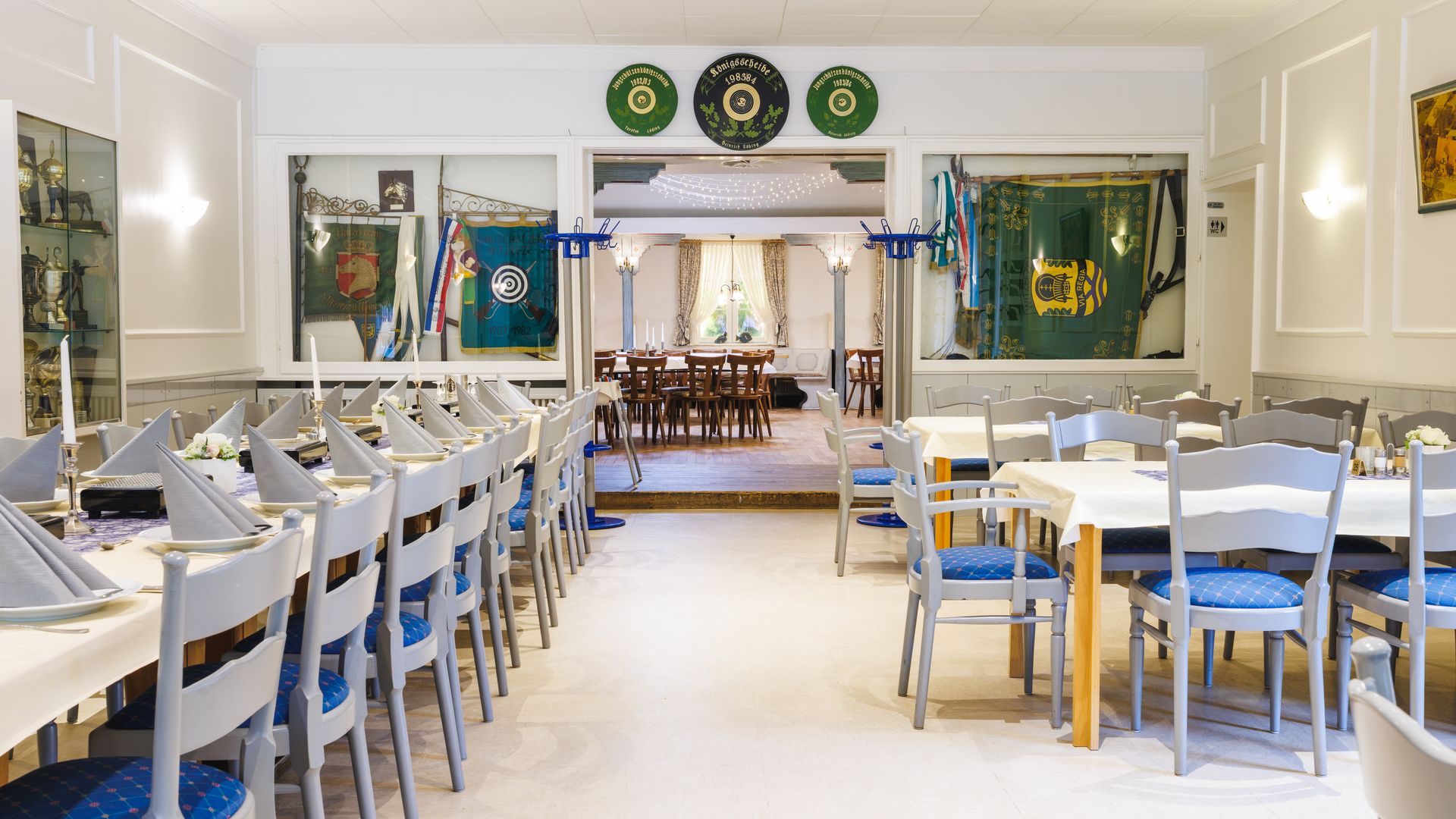 Gastraum mit Tischen und Stühlen und einer Tür im Hintergrund