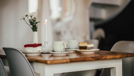 Ein Tisch in einem Kaffee, darauf befinden sich eine Kerze, zwei Teller mit Torte und zwei Tassen.