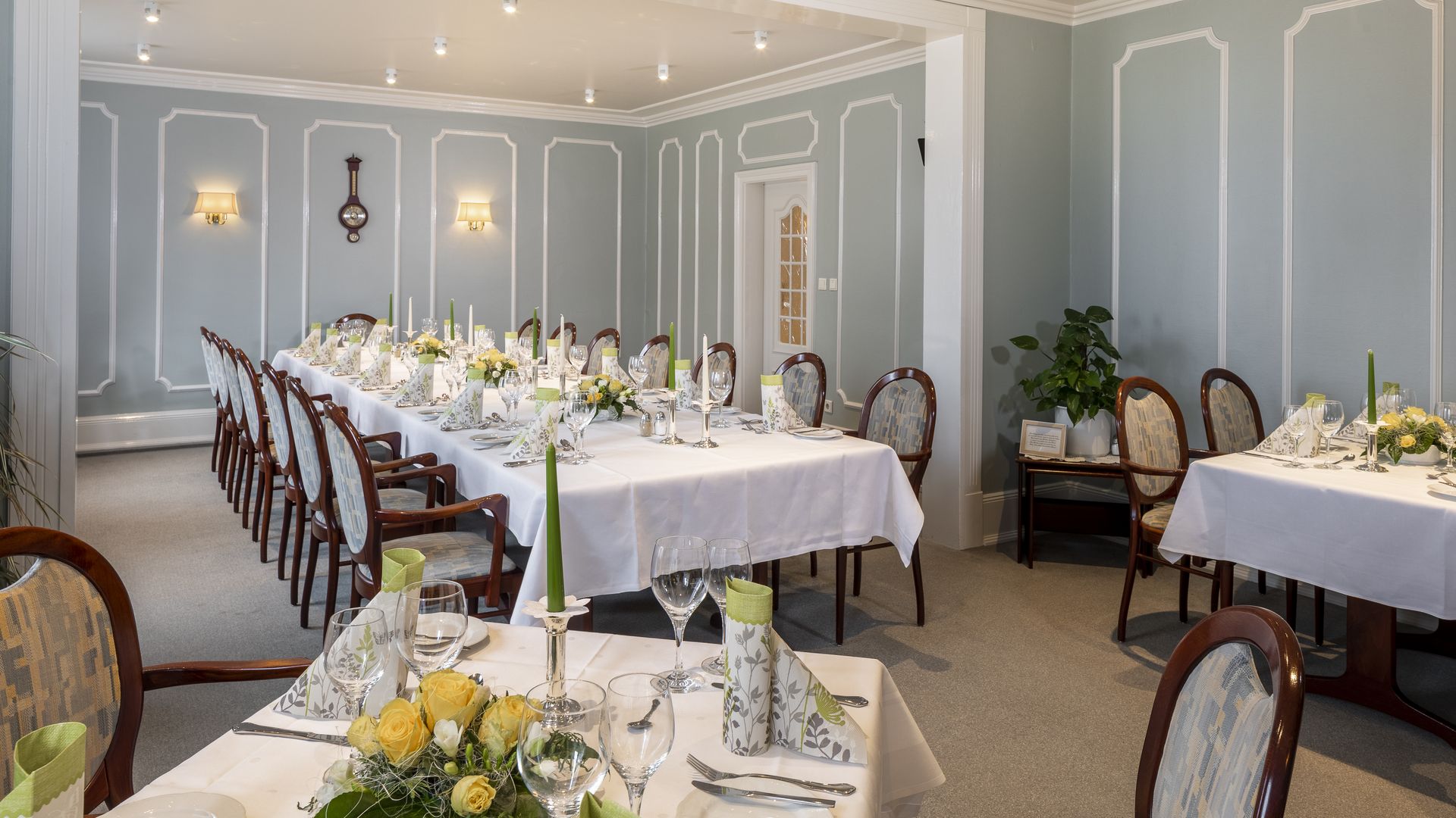 Saal mit blauen Wänden und gedeckten Tischen